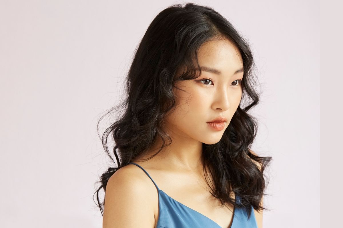 kiểu tóc xoăn hippie sóng to cô gái tóc màu đen mặc váy hai dây màu xanh 