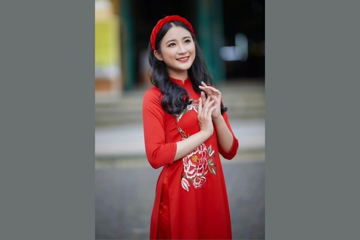 Cô gái mặc áo dài đỏ đẹp có thêu hoạ tiết và đầu đội mấn