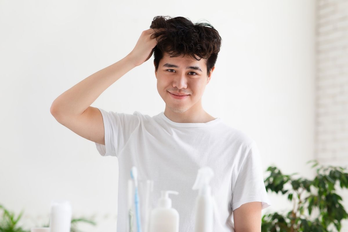 tóc đầu nấm chàng trai mặc áo trắng luôn tay vào tóc