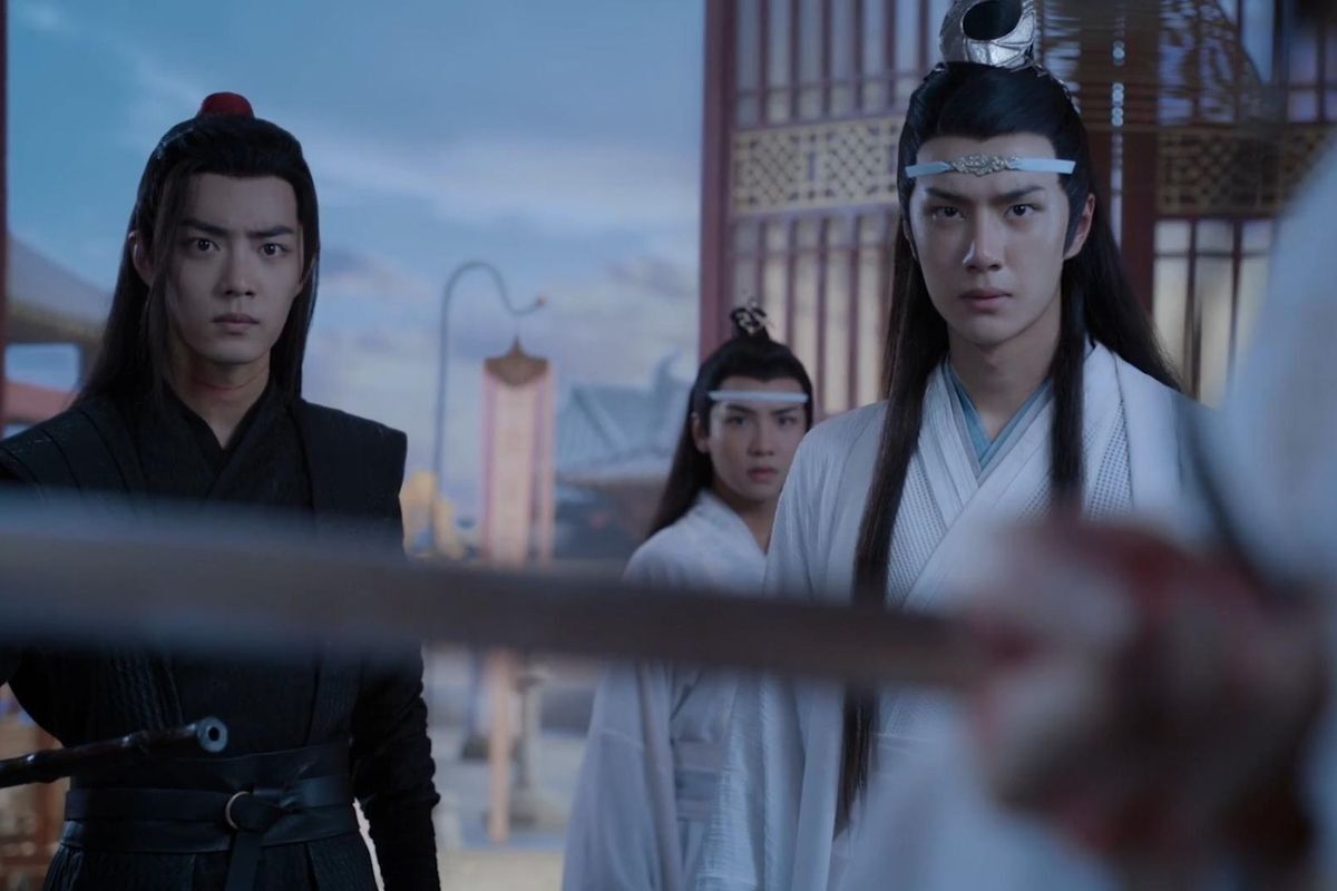 Cảnh phim Trần Tình Lệnh với diễn viên Tiêu Chiến mặc trang phục đen đứng bên trái và Vương Nhất Bác mặc trang phục trắng đứng bên phải