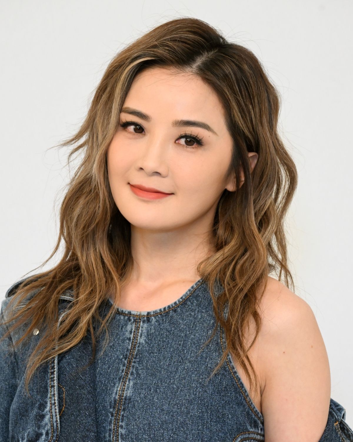 Tóc lỡ tóc lỡ uốn xoăn nhẹ cô gái mặc áo jeans nghiêng đầu