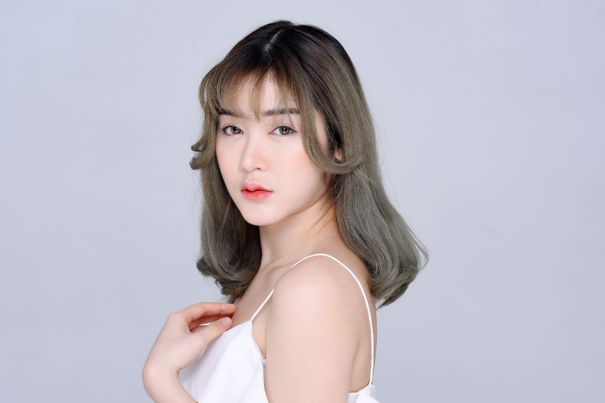 Tóc lỡ kiểu tóc lỡ cho mặt dài mặc váy hai dây màu trắng chụp trên nền xám