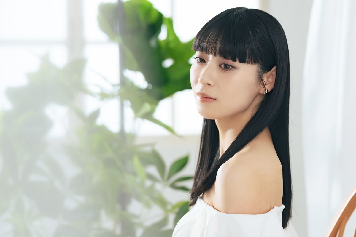 Tóc lỡ kiểu tóc lỡ cho mặt vuông cô gái nhìn xuống dưới ngồi trong phòng có cây xanh