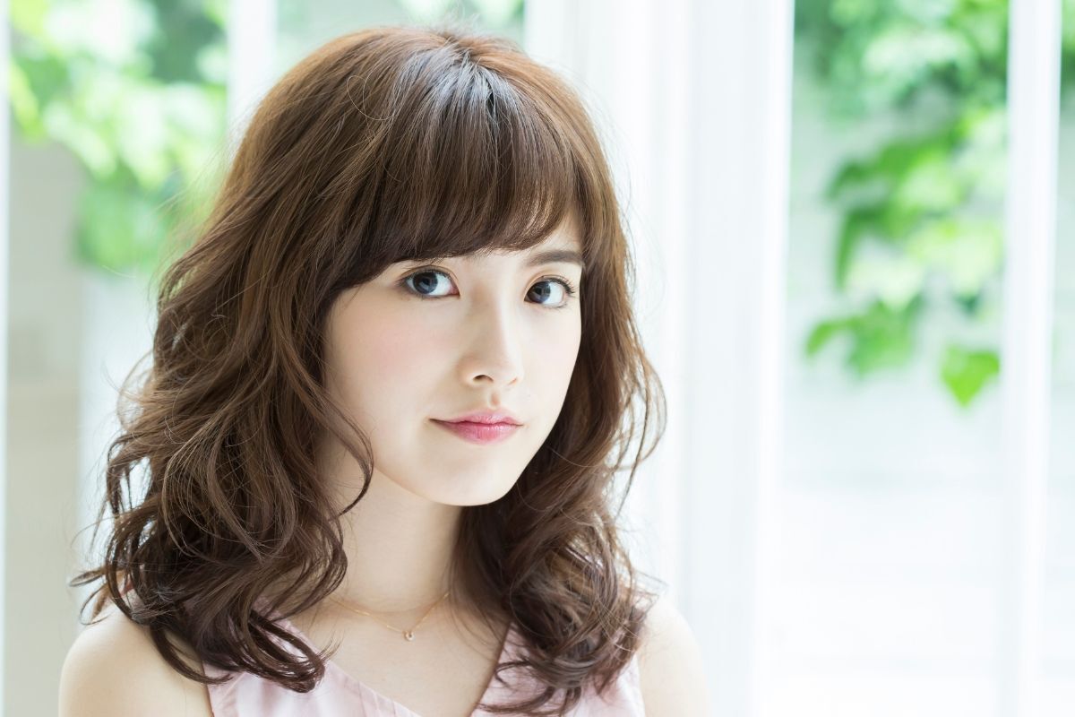 Tóc lỡ tóc lỡ uốn đuôi lọn to cô gái mặc áo màu hồng chụp bên cạnh cửa sổ