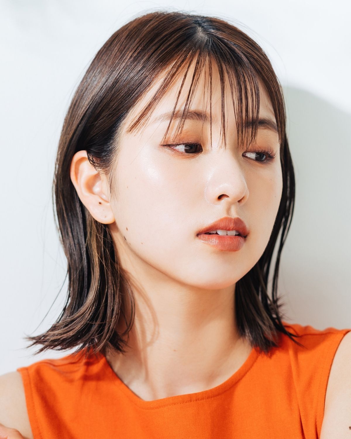  Tóc lỡ tóc ngắn lỡ ngang vai cô gái mặc váy áo màu cam đang nhìn sang bên phải