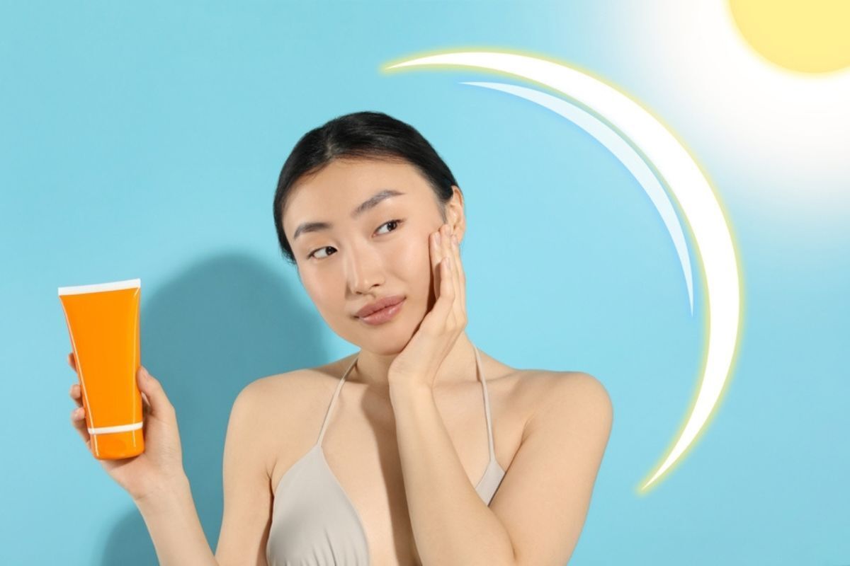 thải độc da mặt các cách thải độc da chống nắng cô gái cầm tuýp kem chống nắng màu cam tay chạm vào một bên má với màng bảo vệ trước ánh sáng mặt trời