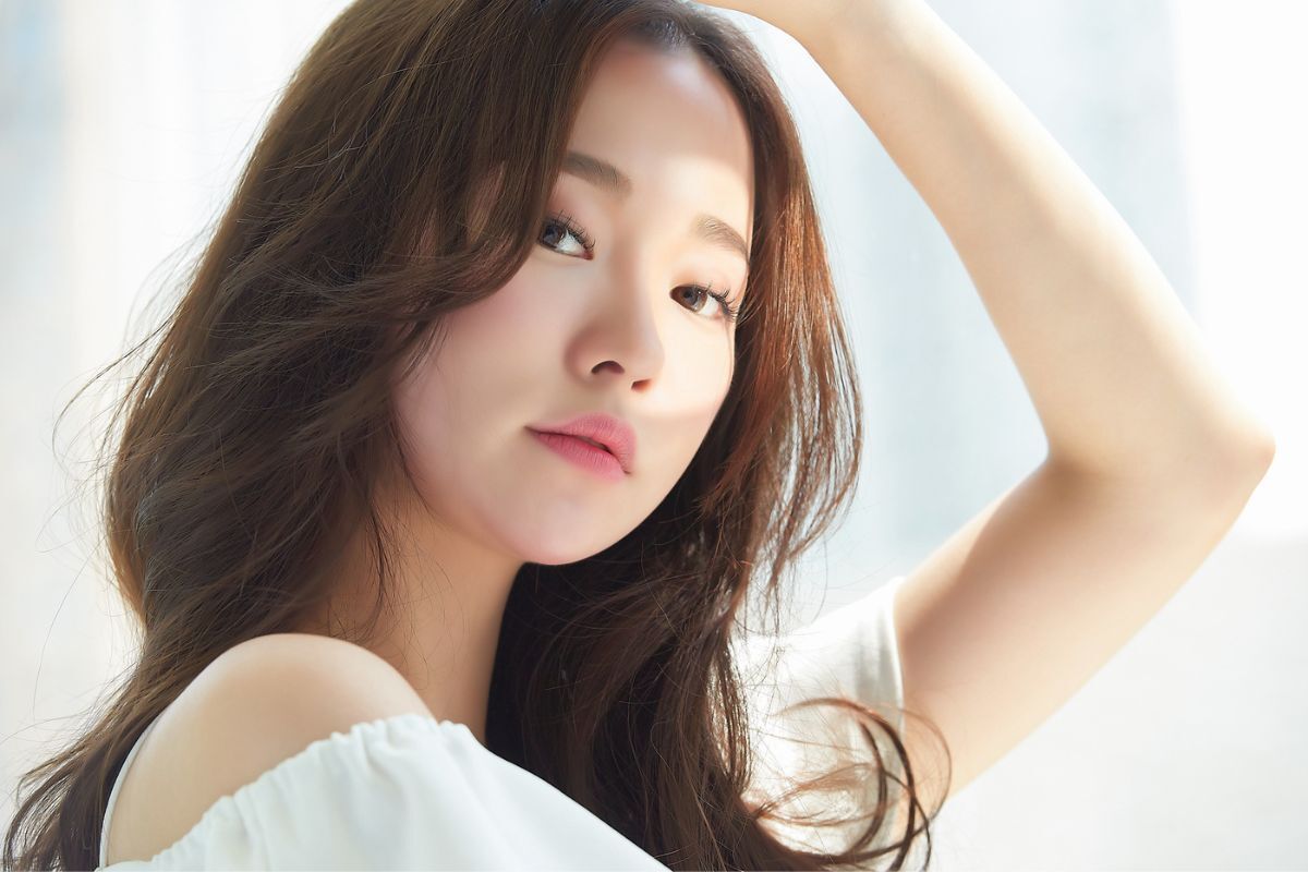 tác dụng phụ của retinol cô gái tóc uốn xoăn nhẹ đứng lấy tay che nắng mắt nhìn thẳng