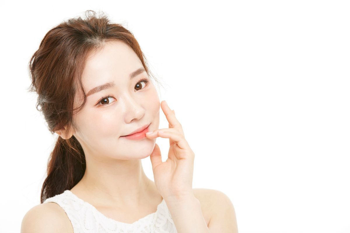 tác dụng phụ của retinol cô gái cột tóc đuôi gà thấp nghiêng đầu nhẹ nhìn thằng cười mỉm tay chạm nhẹ vào má và môi