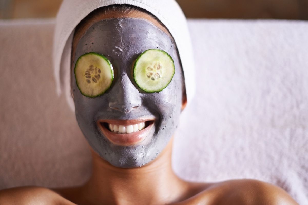 thải độc da mặt các cách thải độc da đắp mặt nạ thải độc da mặt cô gái đắp mặt nạ than tre với hai lát dưa leo trên mắt nằm trên giường cười tươi