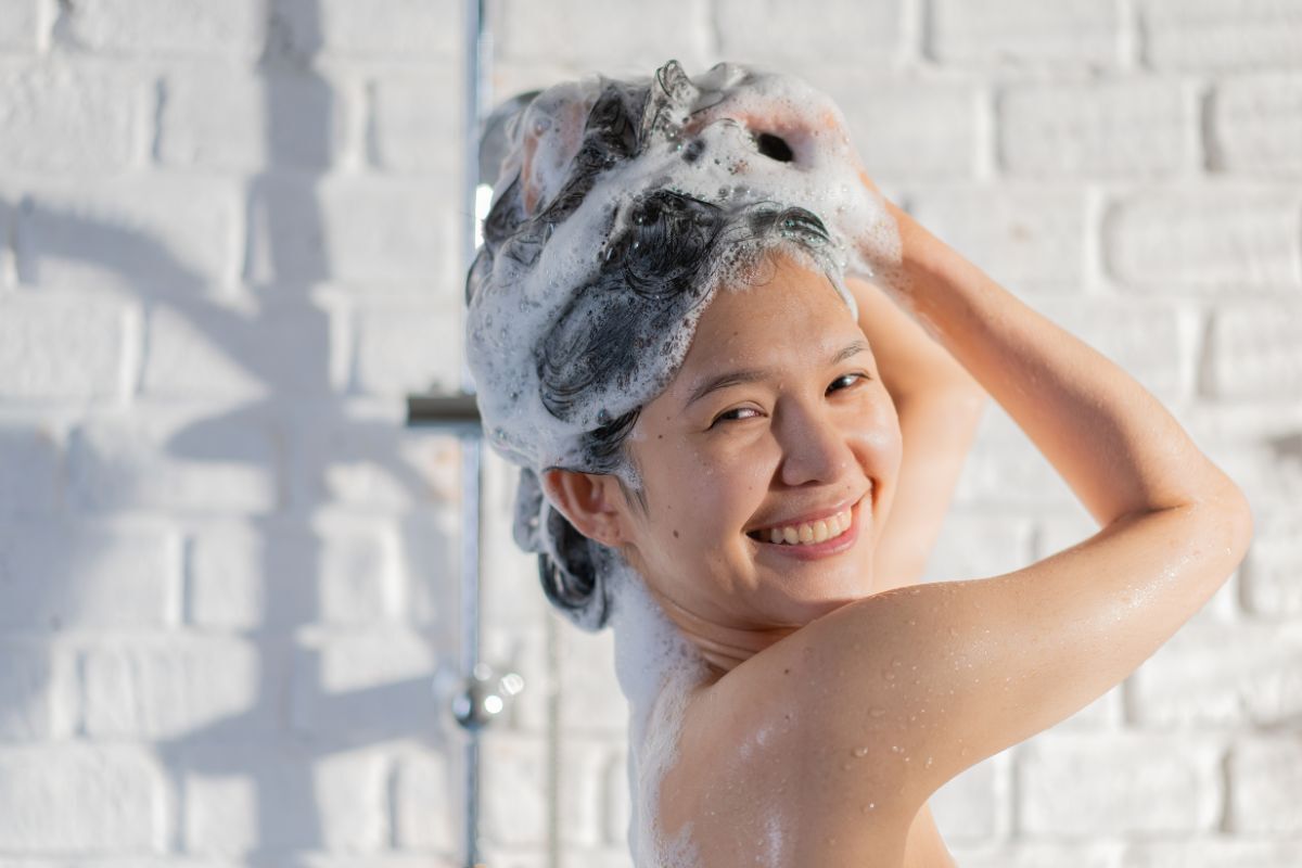 Cô gái cười tươi đang gội đầu