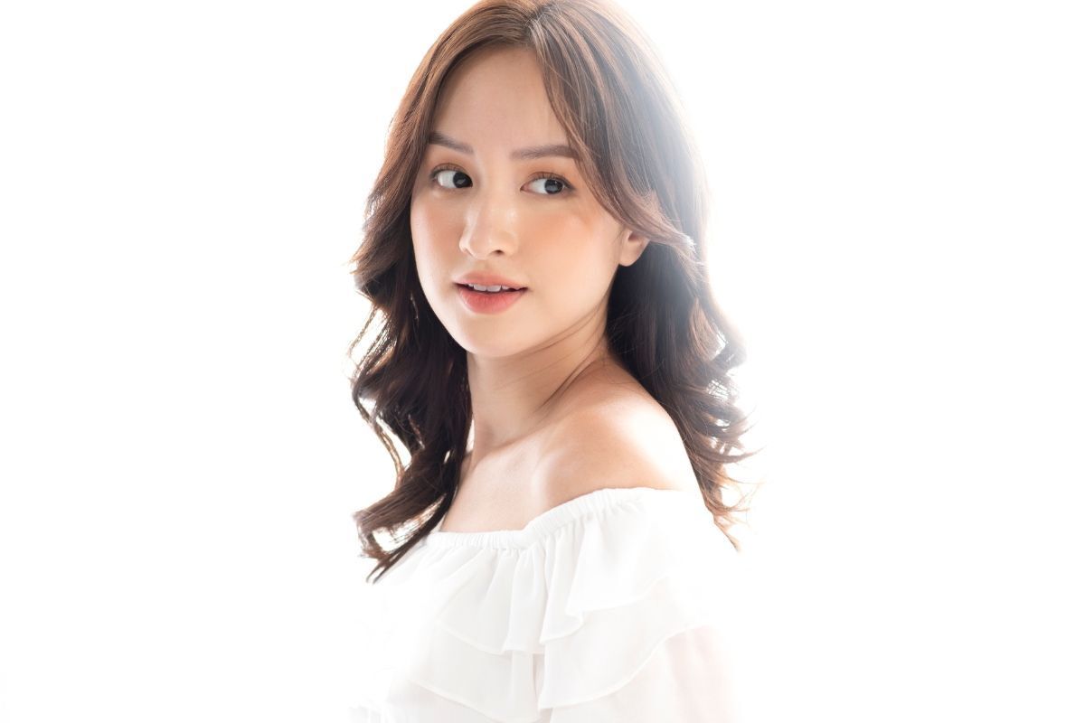 Cô gái có mái tóc xoăn sóng nước màu nâu đen chụp trên nền trắng