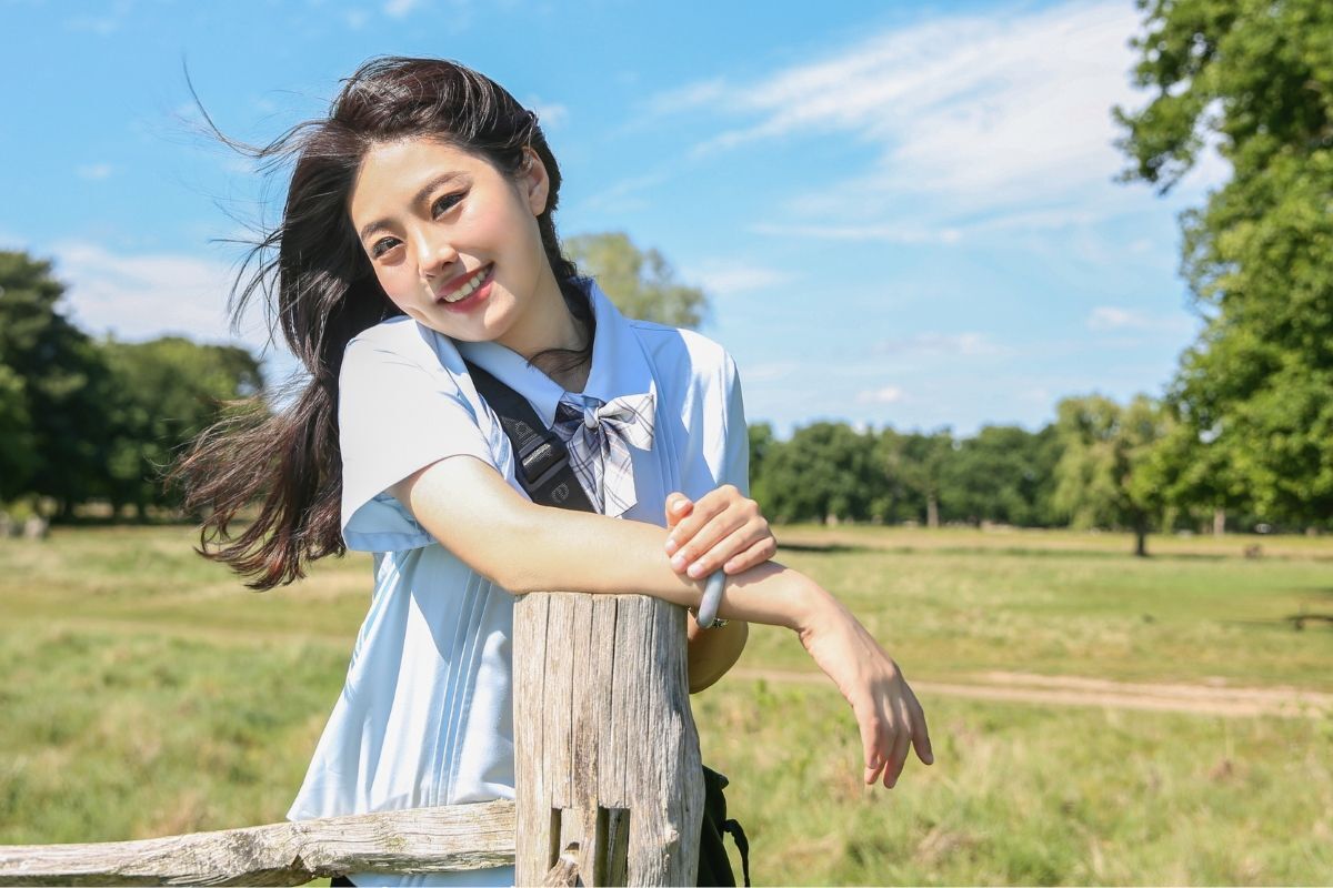 bốn màu tóc nhuộm ra nắng mới thấy cô gái cười tươi dựa vào thanh gỗ đứng chụp ngoài cánh đồng đầy nắng và gió