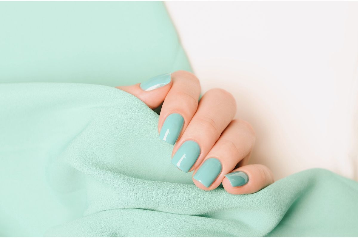 nail pastel màu xanh ngọc trên nền vải cùng màu