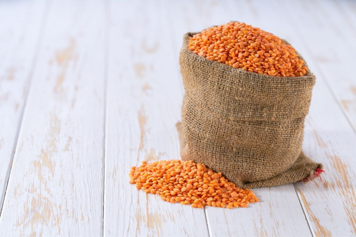 ăn gì để tóc mọc nhanh chất sắt đậu lăng túi đậu lăng kế bên nhúm đậu lăng trên nền gỗ trắng