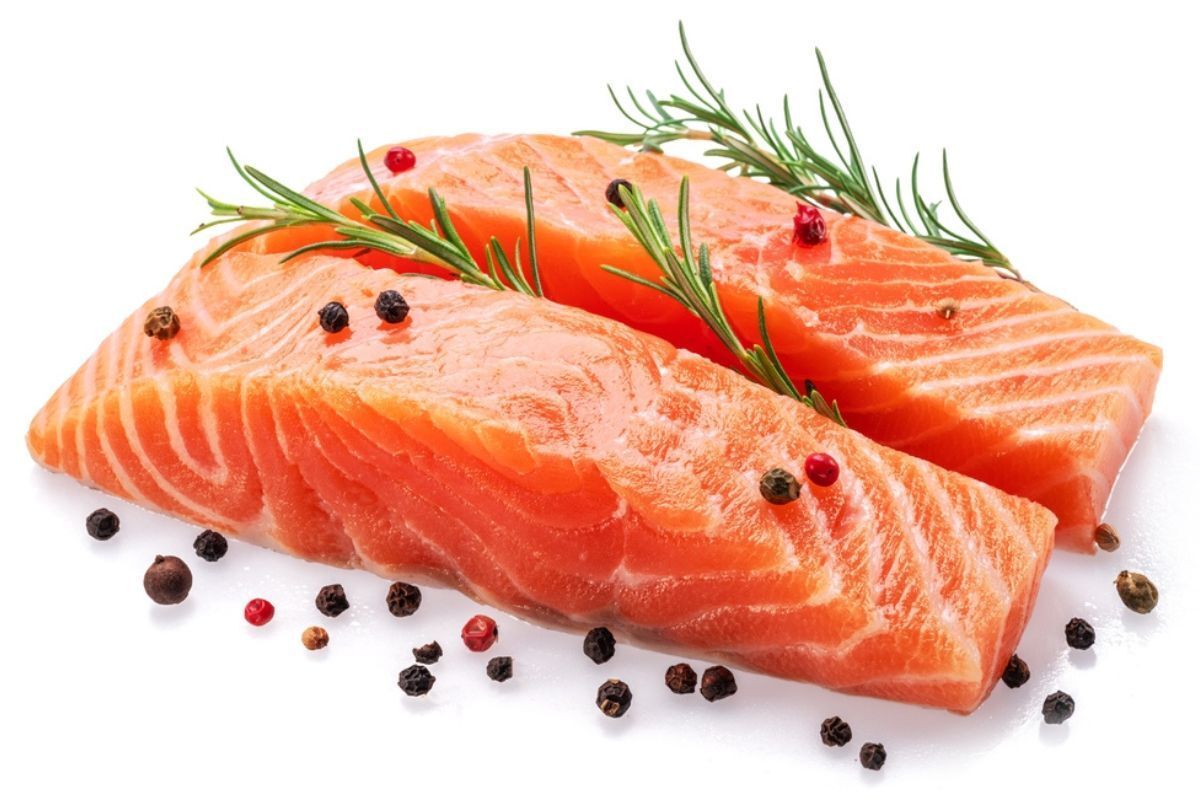 ăn gì để tóc mọc nhanh kẽm cá béo hai miếng phi lê cá hồi sống với hương thảo và hạt tiêu đen trên nền trắng