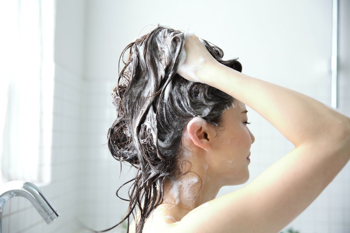 dầu gội cho tóc nhuộm cô gái đứng gội đầu