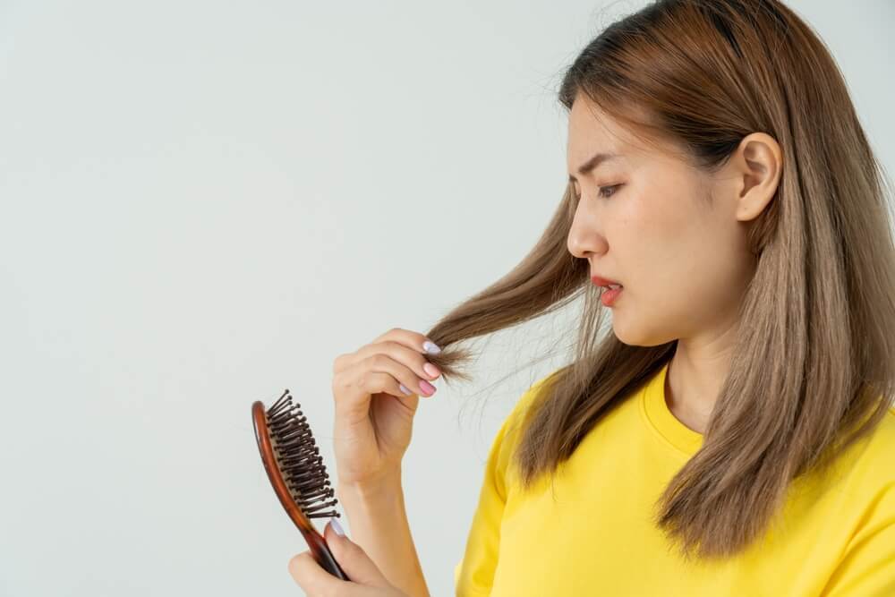 biotin mọc tóc những đối tượng nào nên bổ sung Biotin mọc tóc cô gái mặc áo vàng tay cầm lược và tay cầm tóc khuôn mặt lo lắng