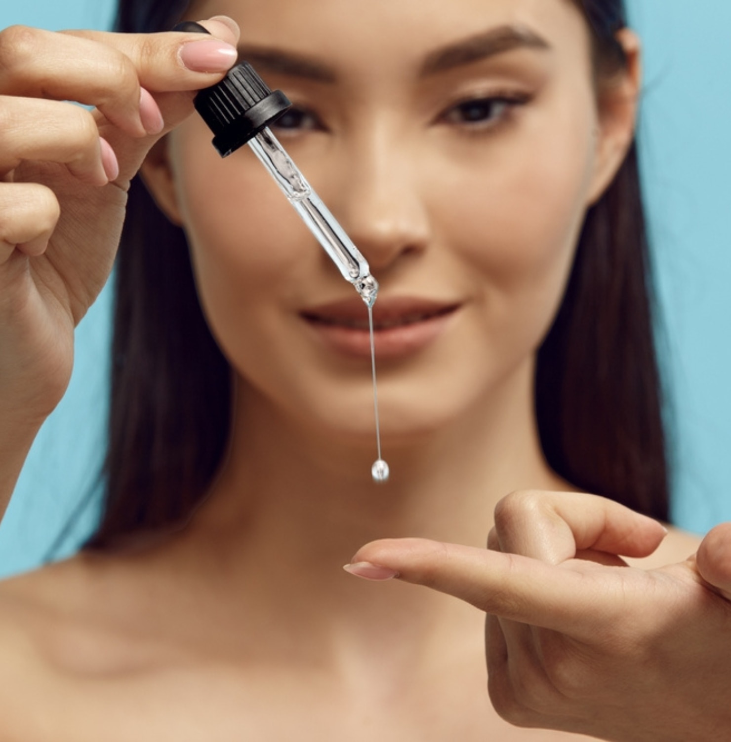 chăm sóc da mụn các bước chăm sóc da mụn vào buổi tối cô gái đang nhỏ serum trong ống thuỷ tinh ra ngón tay