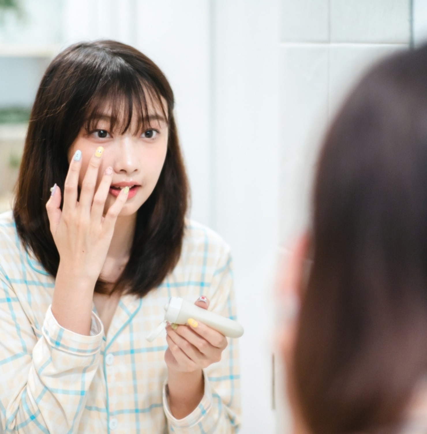 chăm sóc da mụn mẹo chăm sóc da mụn tuổi dậy thì cô gái đang soi gương và thoa kem dưỡng