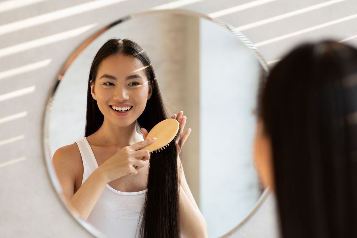 các loại lược chải tóc cô gái chải tóc trước gương cười tươi