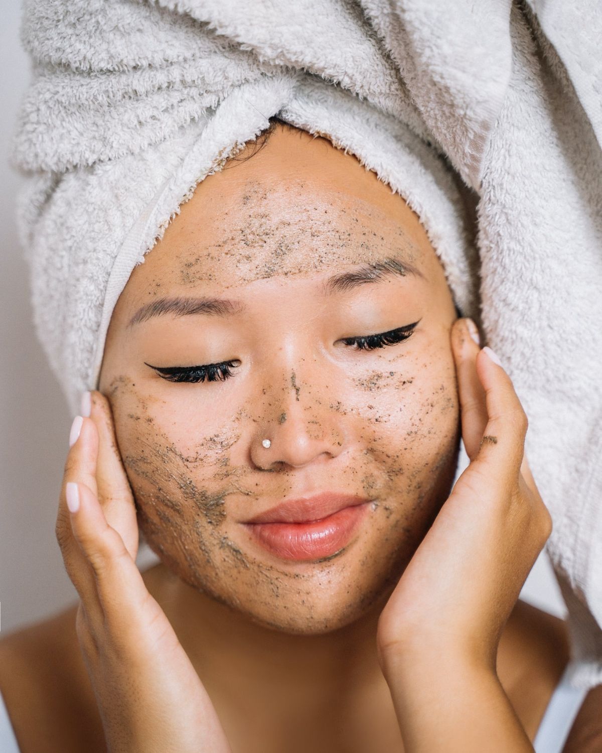 Cô gái nhắm mắt và tẩy da chế bằng hạt scrub màu đen xám