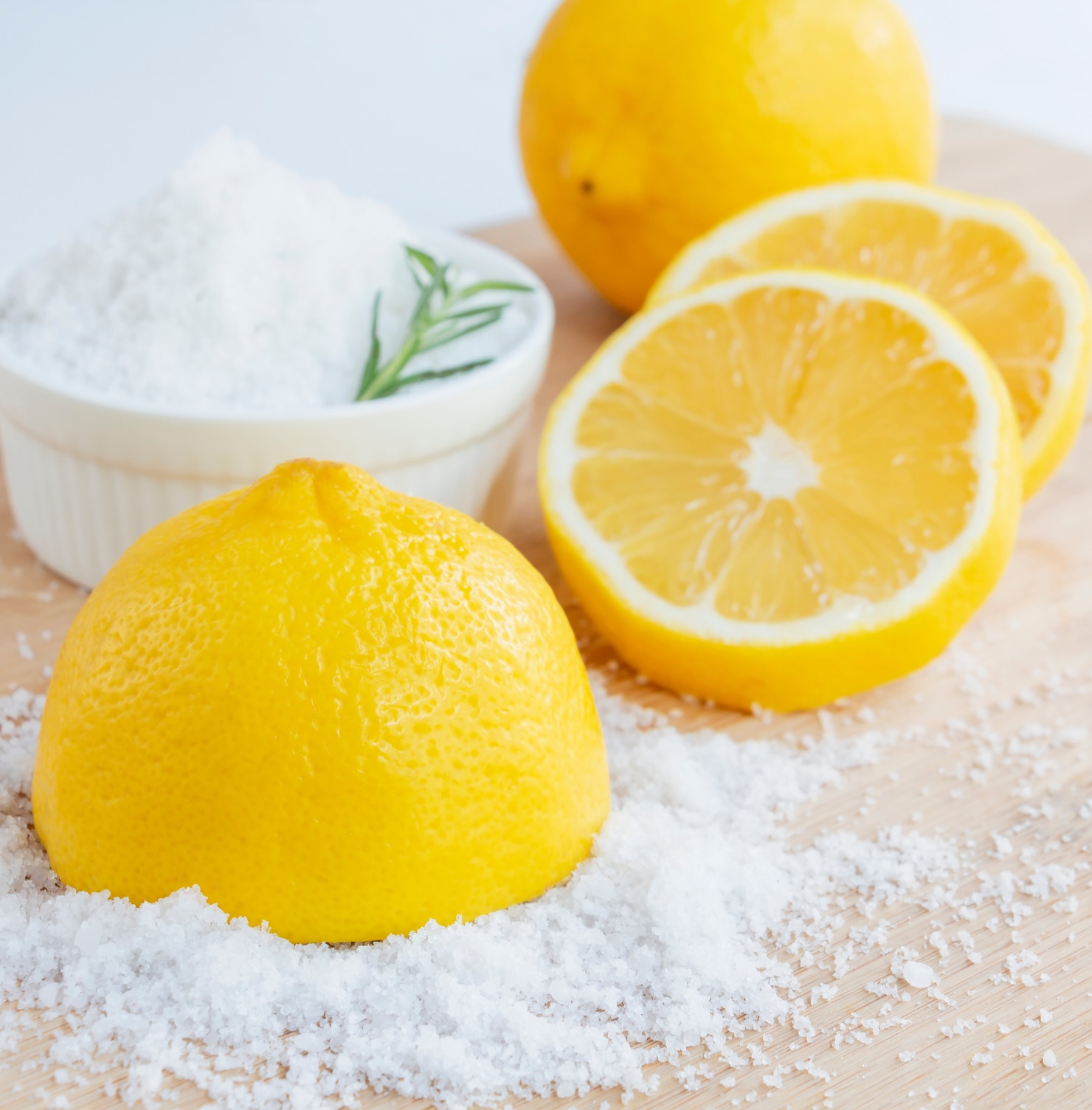 cách trị thâm nách cách trị thâm nách bằng chanh và muối quả chanh cắt đôi đặt bên cạnh bát đựng muối trắng