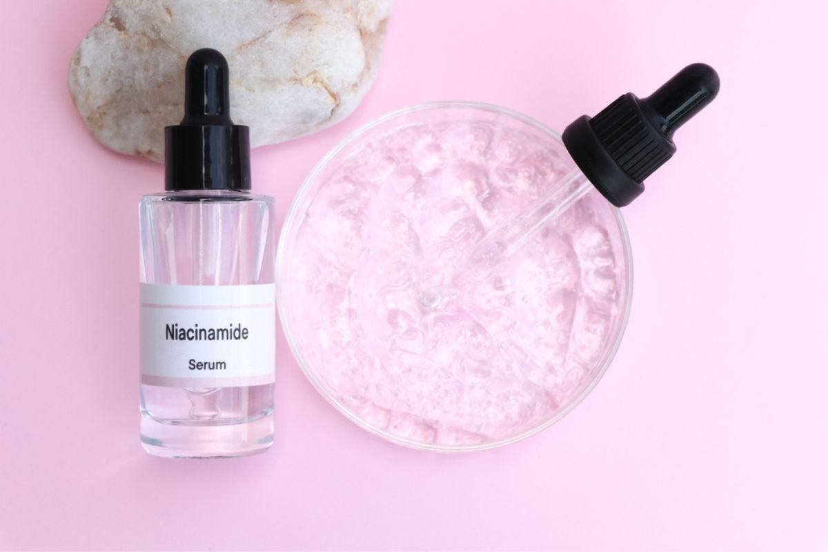 hyaluronic acid kết hợp với niacinamide chai serum niacinamide kế bên dĩa tròn trên nền hồng