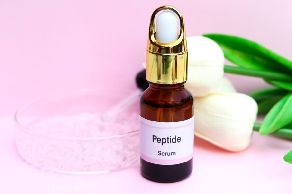 hyaluronic acid kết hợp với peptide chai serum peptide kế bên dĩa tròn trên nền hồng