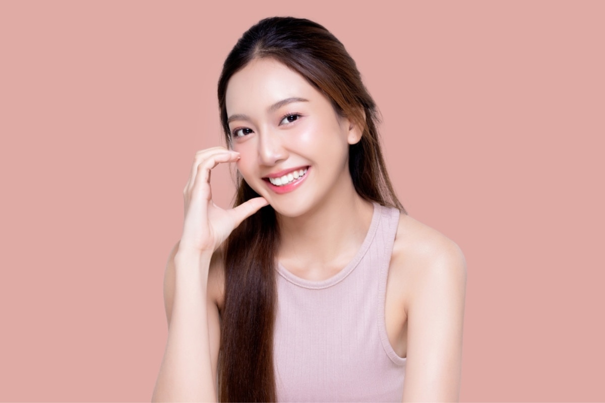 cách trị tàn nhang cô gái tạo hình trái tim bằng tay vào má.