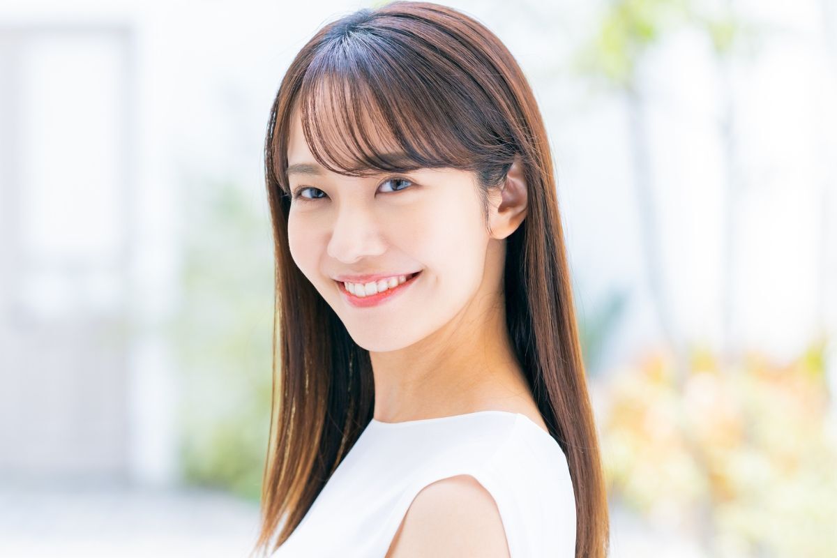 Kiểu tóc dài với mái bằng cô gái có khuôn mặt hình chữ nhật đang cười tươi