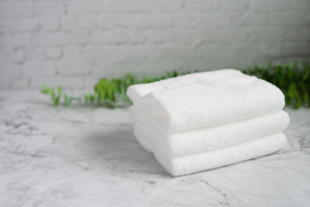 chườm đá lên mặt sử dụng khăn cotton mỏng 3 chiếc khăn màu trắng xếp gọn gàng được đặt chồng lên nhau