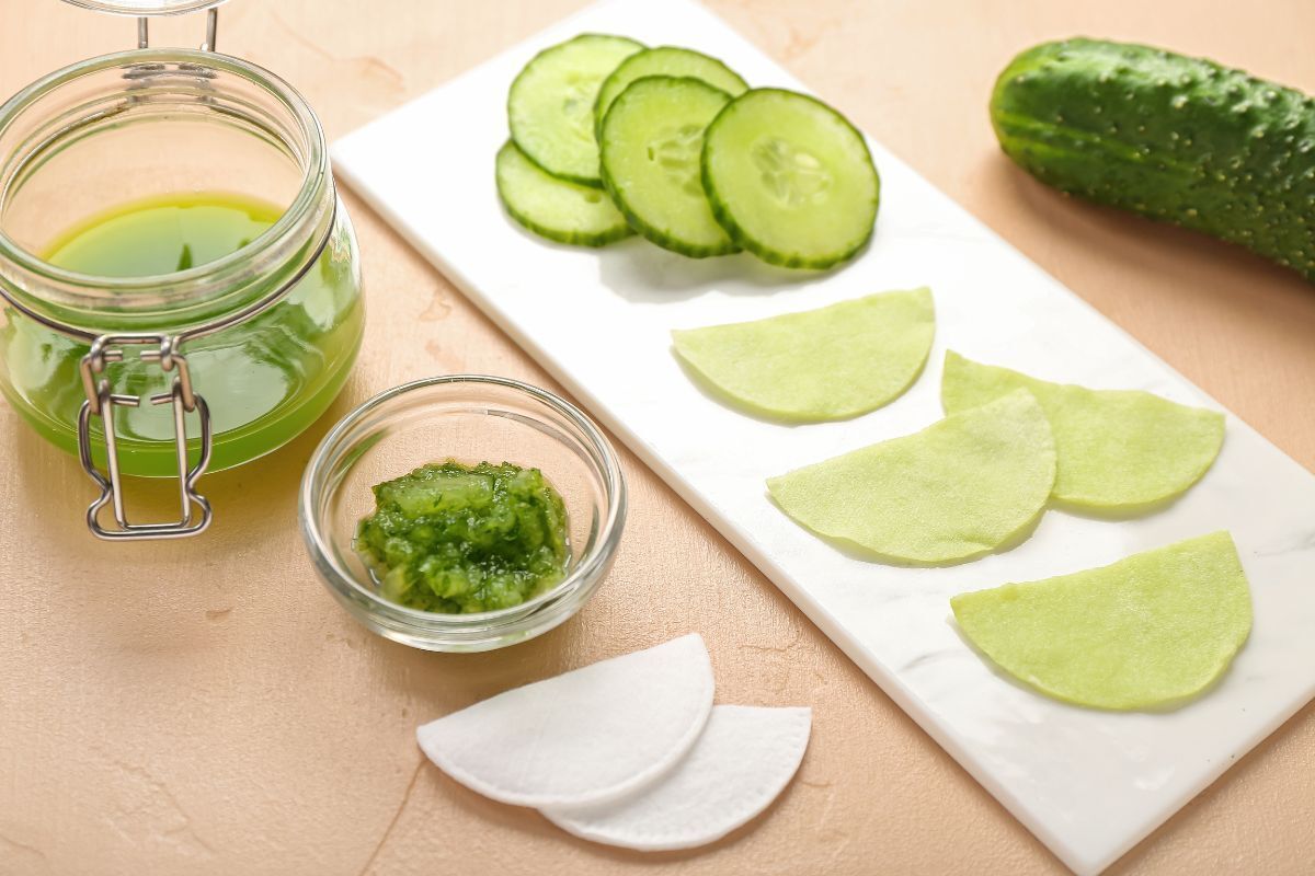 mặt nạ nâng cơ dưa leo cắt lát, nghiền nát thành bã và nước bên cạnh miếng bông tẩy trang