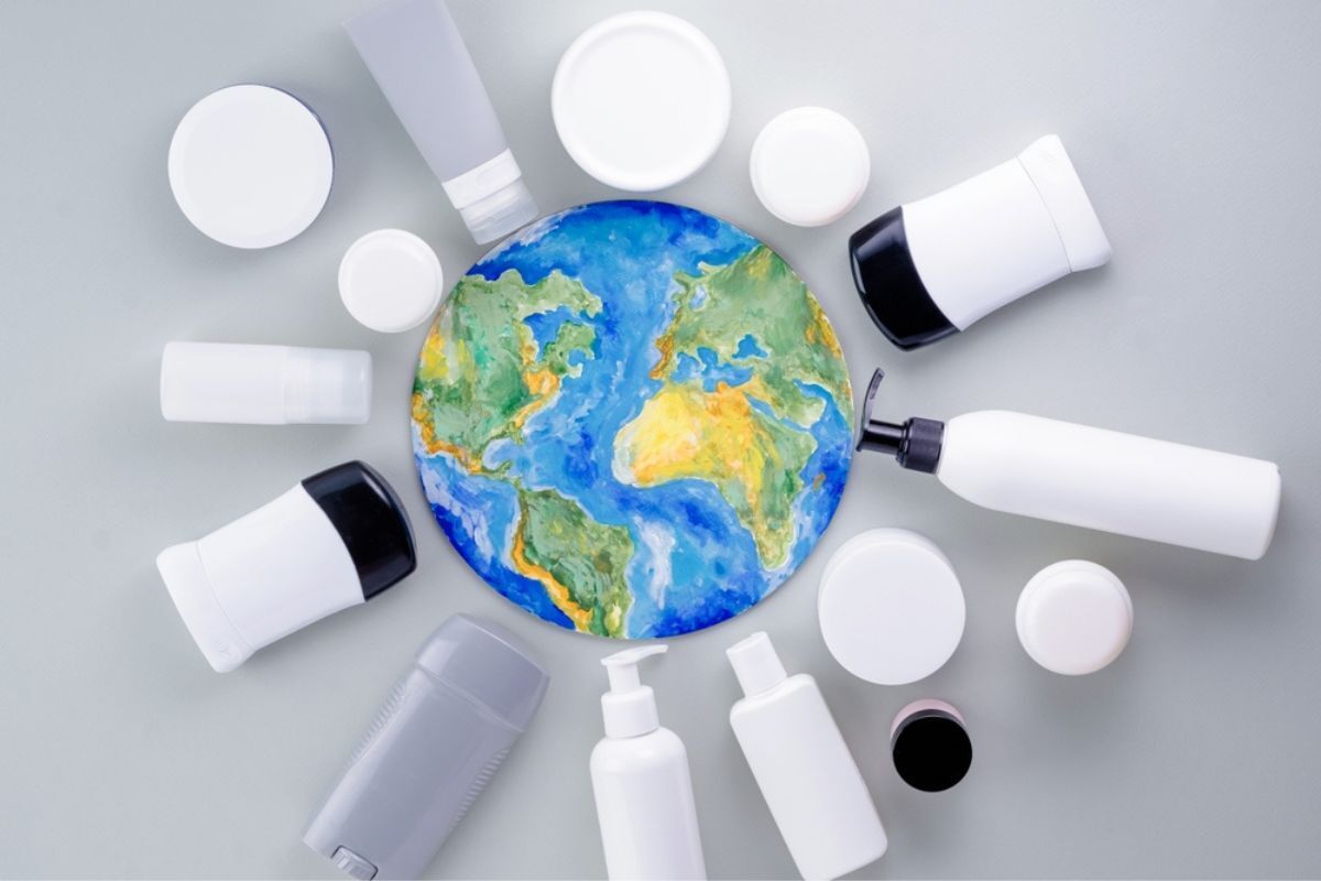 bao bì mỹ phẩm tác động của bao bì mỹ phẩm lên hành tinh xanh chai lọ nhựa màu trắng xếp xung quanh hình vẽ trái đất trên nền xám