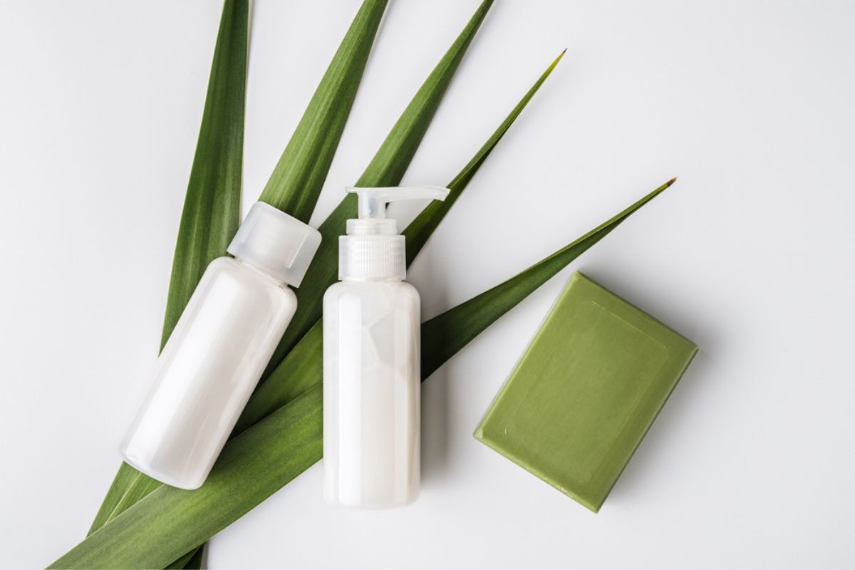 bao bì mỹ phẩm từ nhựa phân huỷ sinh học chai lọ nhựa màu trắng đựng mỹ phẩm trên nền lá xanh