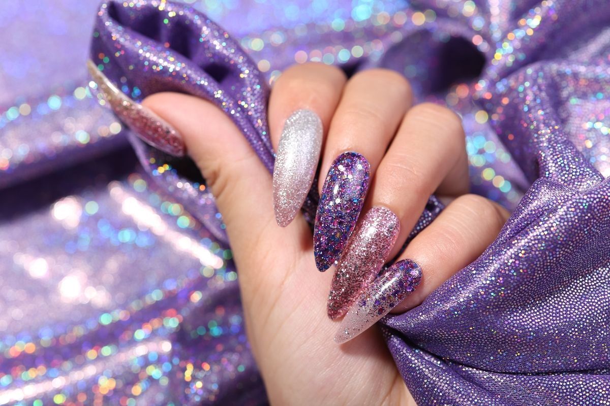 nail nhũ bàn tay nail nhũ màu tím phối bạc cầm miếng vải màu tím kim tuyến