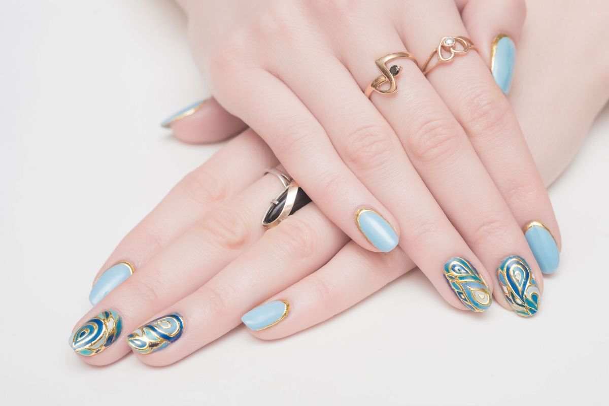 nail màu xanh dương nhạt xen kẽ màu xanh đậm có vẽ họa tiết bàn tay có ngón giữa và ngón áp út đeo nhẫn