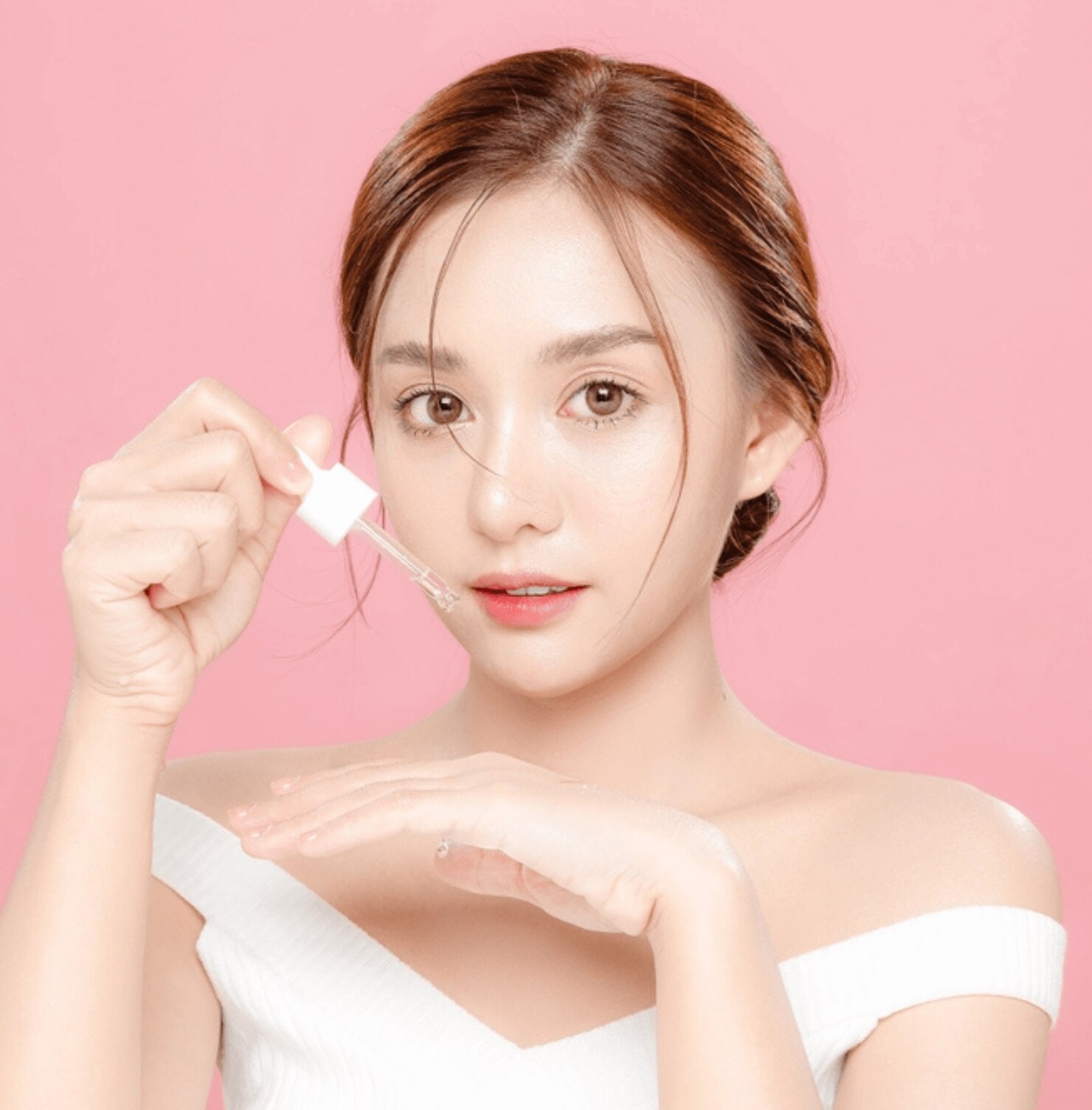 da không đều màu cô gái cầm nắp chai serum đang nhỏ giọt lên bàn tay