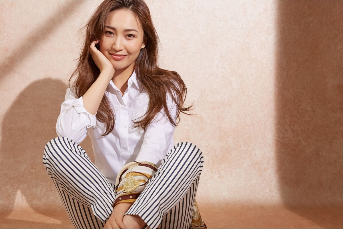 tóc màu nâu tây ánh đồng cô gái tóc màu nâu tây ánh đồng tay chống cằm mặc áo sơ mi trắng quần sọc xanh ngồi dưới đất