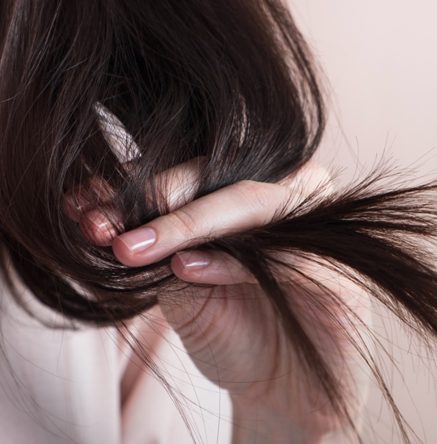 vitamin b1 có tác dụng gì cho tóc ngăn ngừa tóc chẻ ngọn và giòn cô gái tay cầm ngọn tóc màu đen chụp cận