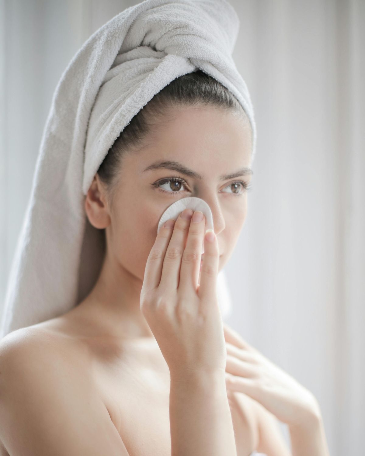 Toner pad đừng bỏ qua bước dưỡng ẩm da cô gái quấn khăn trên đầu và thoa toner lên da 