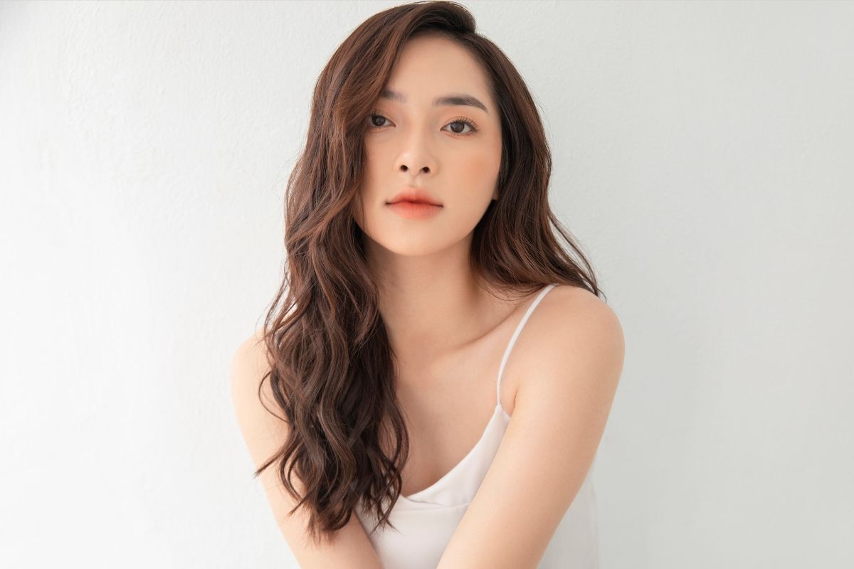 5 mẹo để có tóc uốn đẹp mà không bị già cô gái mặc áo hai dây màu trắng chụp trên nền trắng