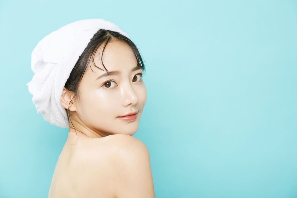 da đầu dầu cô gái quấn khăn tắm màu trắng trên đầu