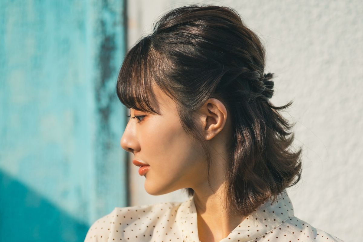 Kiểu tết tóc ngắn đẹp cô gái mặc áo sơ mi chấm bi đang nhìn sang bên trái