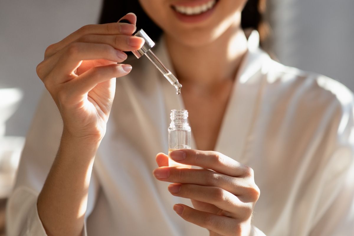 serum chống lão hóa dưỡng ẩm cô gái đang sử dụng ống lấy serum
