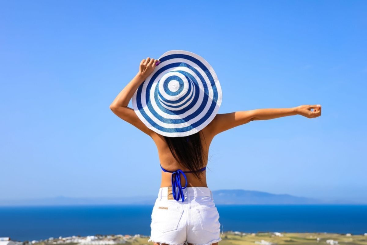 tắm nắng tắm nắng đúng cách cho người lớn cô gái đội nón đứng quay lưng trước biển