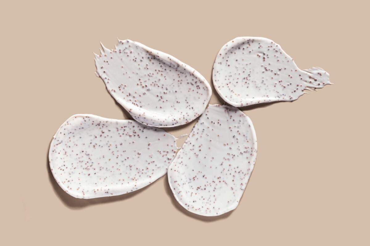 cách tẩy da chết tại nhà vì sao nên sử dụng tẩy tế bào chết body từ nguyên liệu thiên nhiên kem tẩy tế bào chết chứa hạt vi nhựa trên nền màu be xám