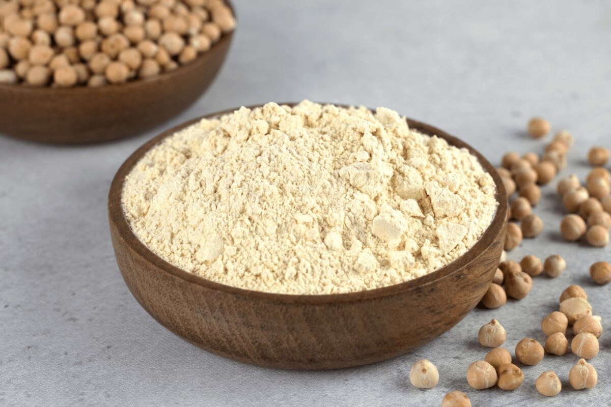 cách tẩy da chết tại nhà bột đậu gà nghiền mịn đựng trong bát gỗ màu nâu