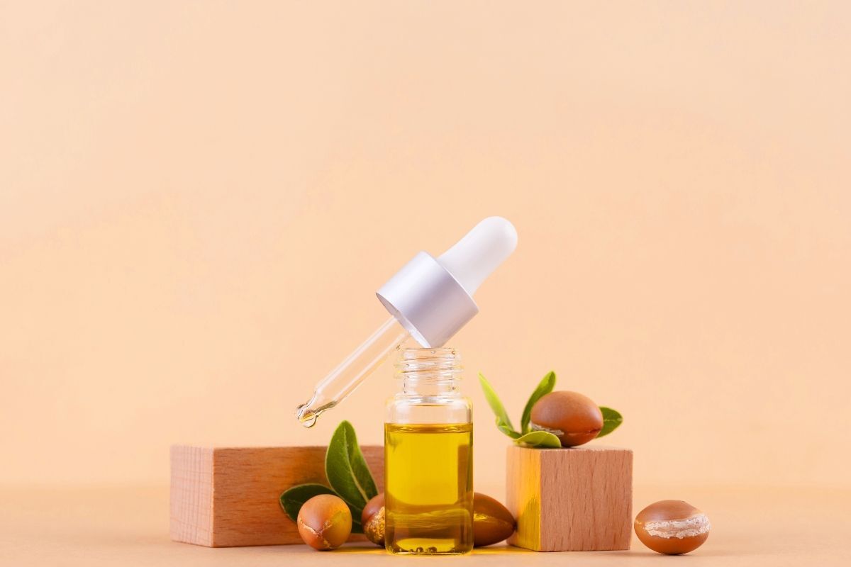 tinh dầu dưỡng tóc uốn dầu argan trên nền cam nhạt
