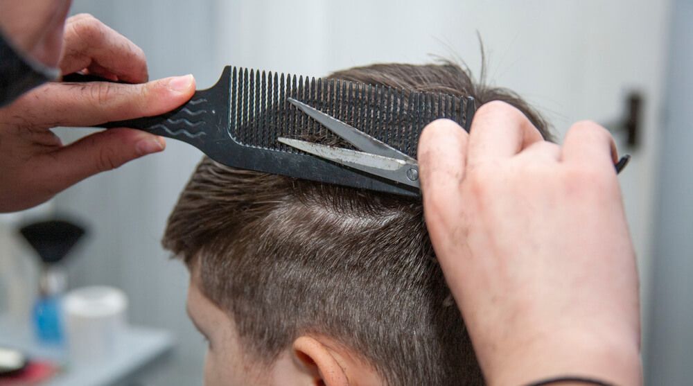 dưỡng tóc nam cách nuôi tóc dài nam hai bàn tay cầm lược và kéo tỉa tóc cho chàng trai