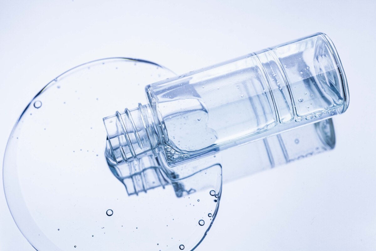 da nhạy cảm cấp nước cho da chai toner màu xanh nhạt nằm trên nền gương